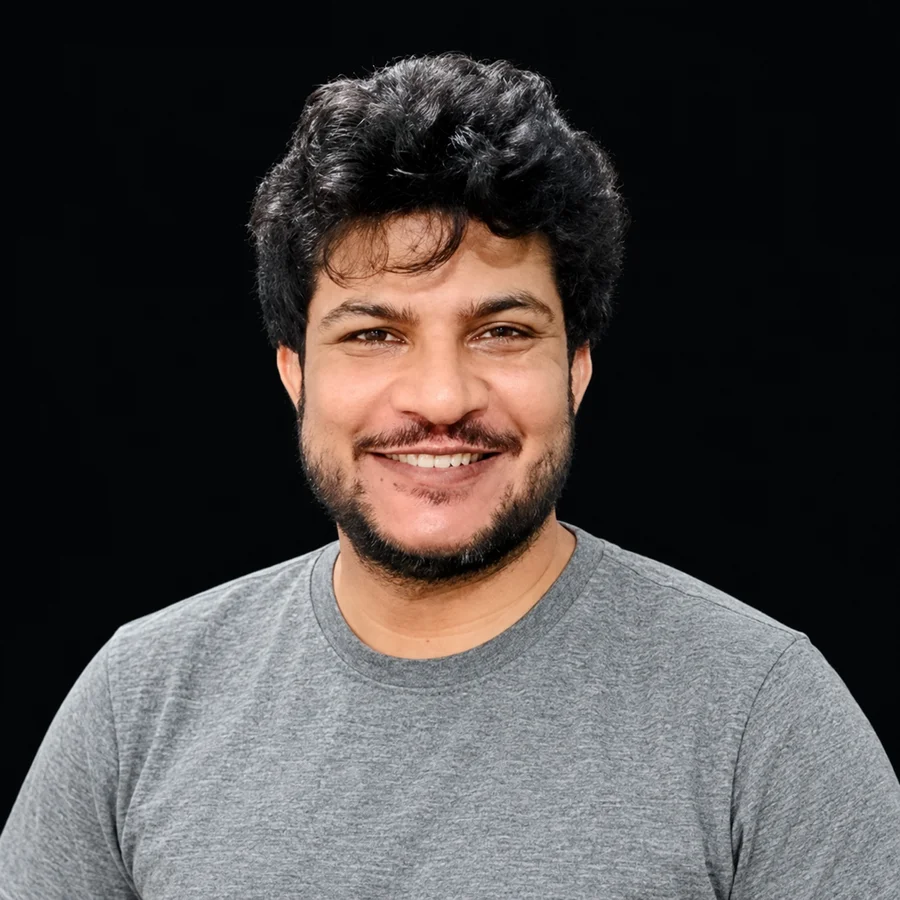 Fahad Younis smiling in a grey shirt.